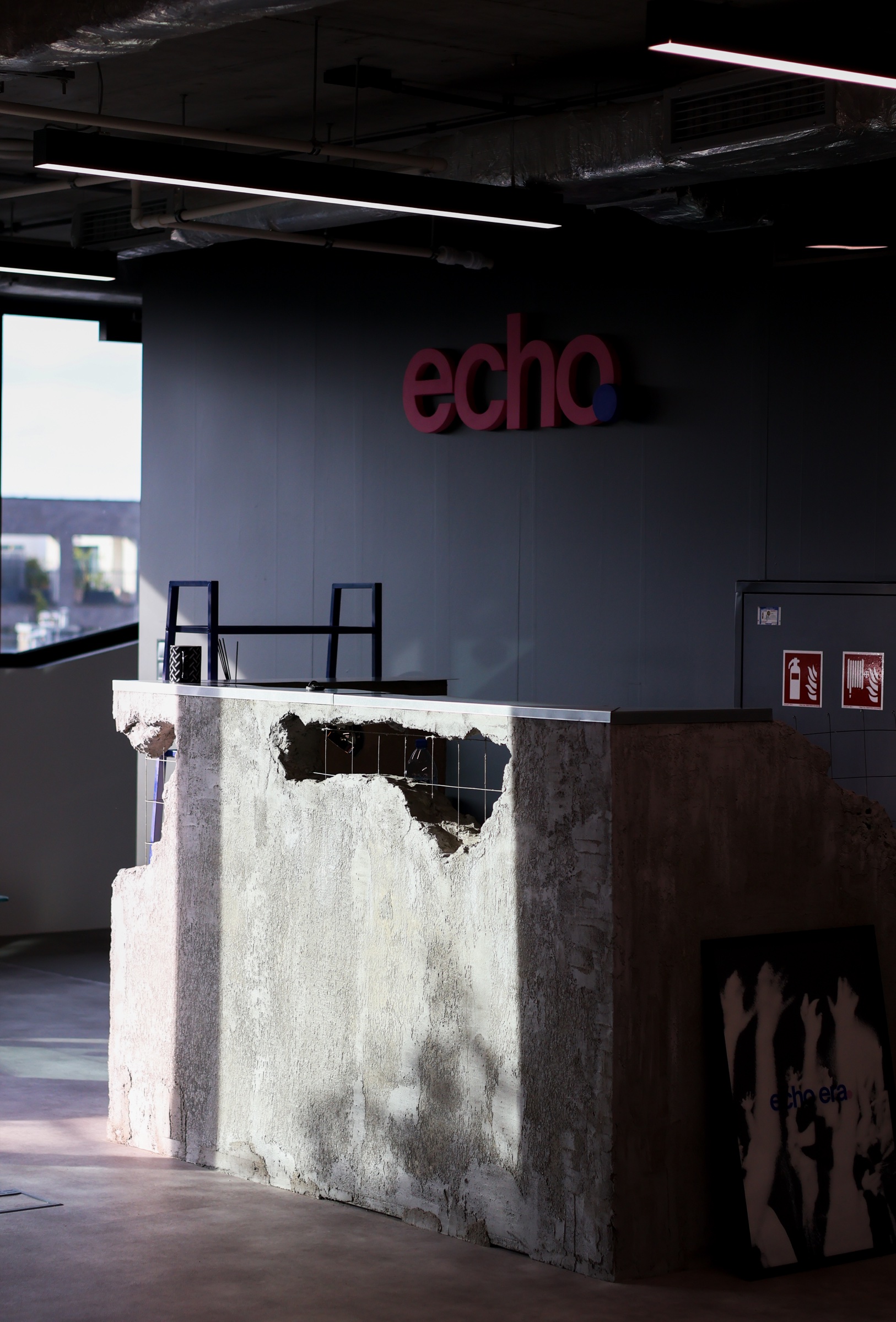 Wnętrze Echo Studio z różowym logo nad surową ladą